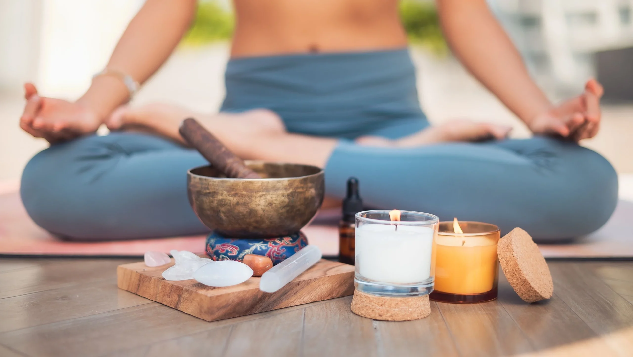 Hands using crystals, sound bowls, and chakra symbols for energy healing techniques